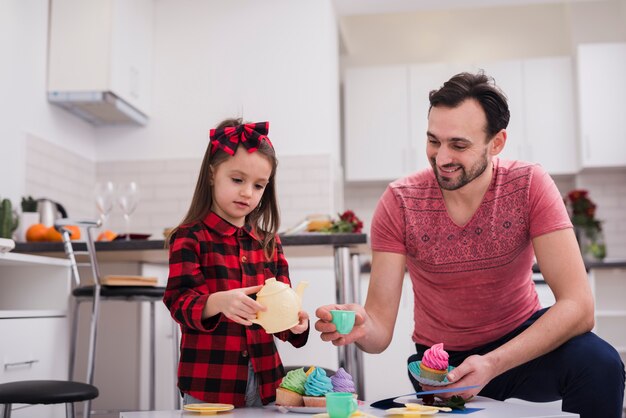 Padre jugando a las tazas con su hija 