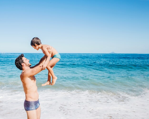 Padre levantando hijo por el agua