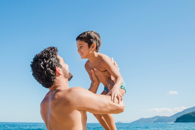 Padre levantando hijo de vacaciones