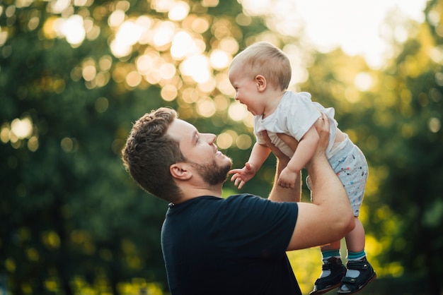 Padre levantando a su hijo en el aire.