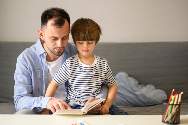 Padre leyendo libro a hijo