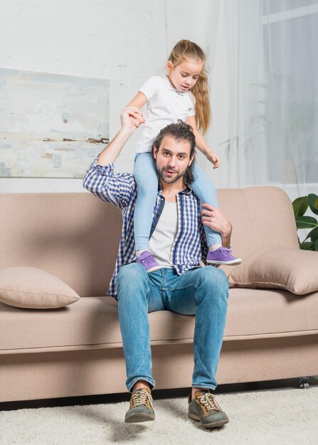 Padre llevando a caballito a su hija