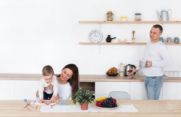 Padre y madre en la cocina con niño y espacio de copia