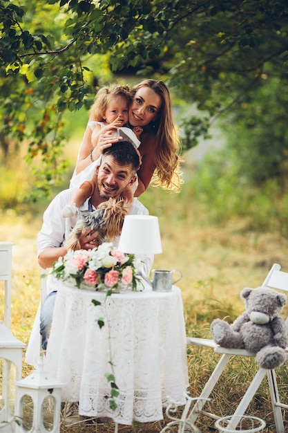 Padre, madre e hija juntos en el picnic en el jardín