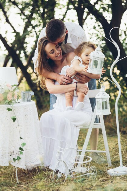 Padre, madre e hija juntos en el picnic en el jardín