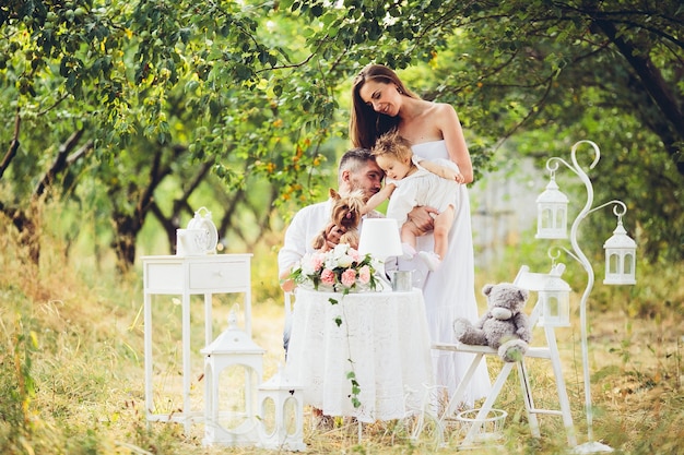 Padre, madre e hija juntos en el picnic en el jardín