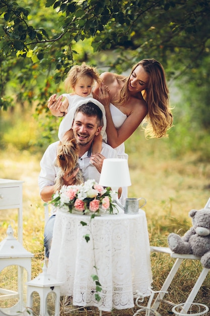 Padre, madre e hija juntos en el picnic en el jardín