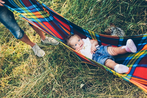 Padre, madre e hija pequeña divirtiéndose al aire libre, jugando juntos en el parque de verano