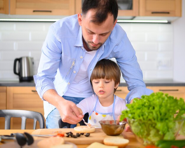 Foto gratuita padre monoparental y niño en la cocina