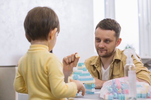 Padre mostrando un trozo de lego a su hijo