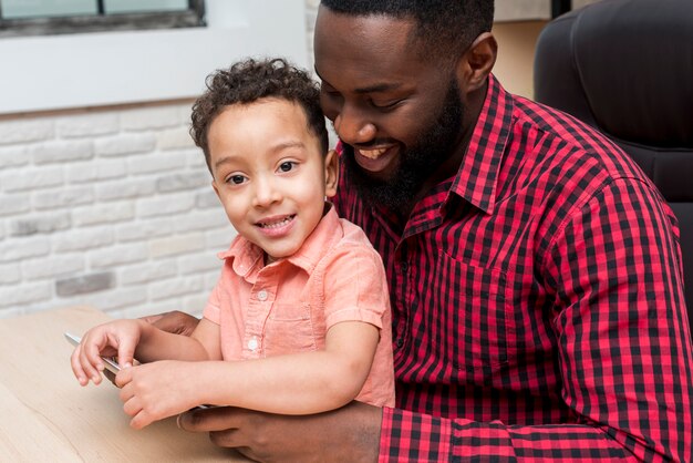 Padre negro e hijo lindo usando tableta