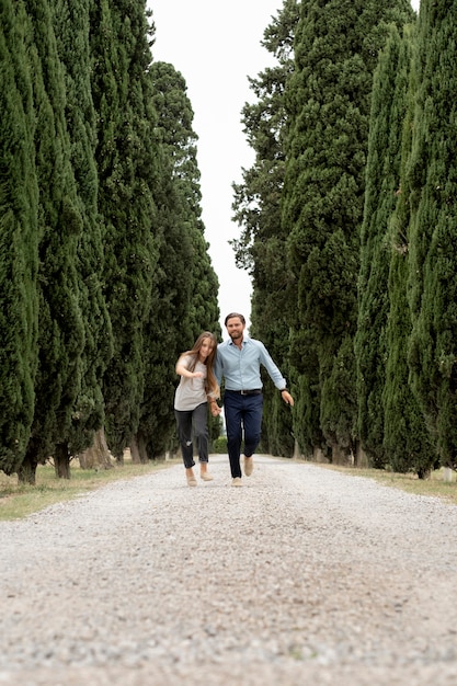 Padre y niña de tiro largo caminando en la naturaleza