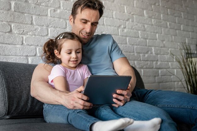 Padre y niña de tiro medio con tableta