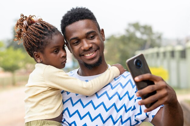 Padre y niña tomando selfies