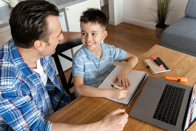 Padre y niño de tiro medio con laptop