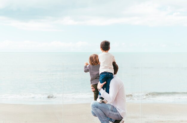 Padre con niños mirando al mar