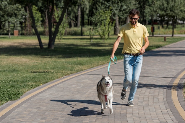 Padre paseando a un perro en el parque