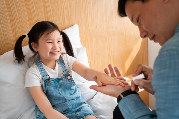 Padre pintando uñas de niña