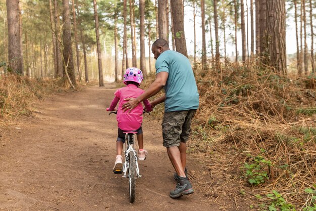 Padre preparando a su hijo para un paseo en bicicleta