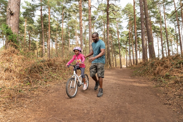 Padre preparando a su hijo para un paseo en bicicleta