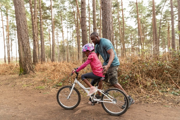 Padre preparando a su hijo para un paseo en bicicleta