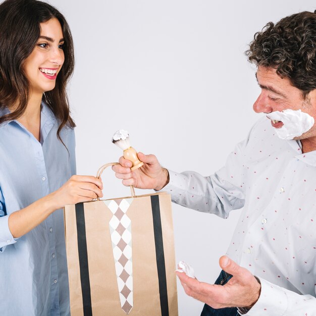 El padre recibe el regalo de la hija durante el afeitado