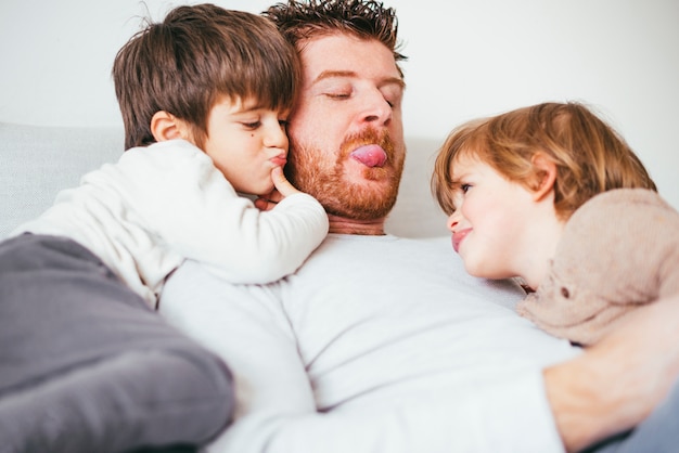 El padre saca la lengua jugando con el niño