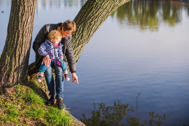 Padre señalando el lago a su hijo