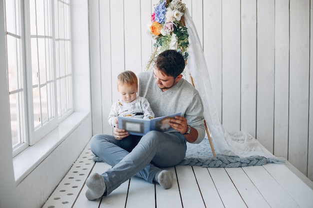 Foto gratuita padre sentado en casa con su pequeño hijo