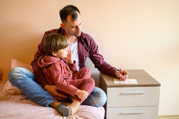 Foto gratuita padre, sentado, con, hijo, en cama