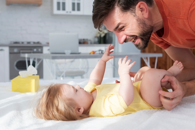 Padre sonriendo y jugando con bebé