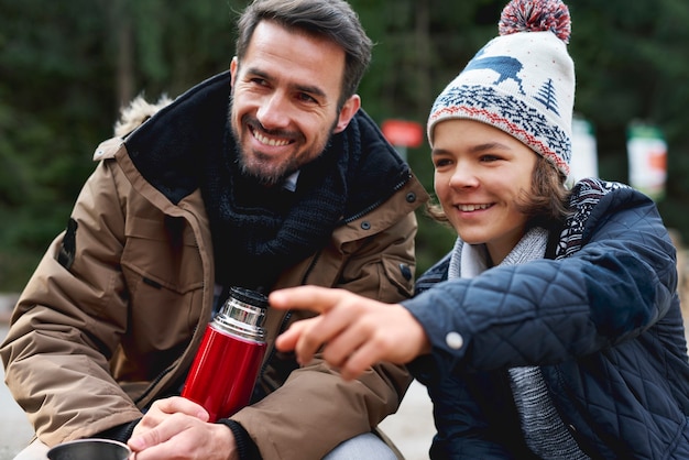 Foto gratuita padre sonriente y su hijo gastando juntos al aire libre