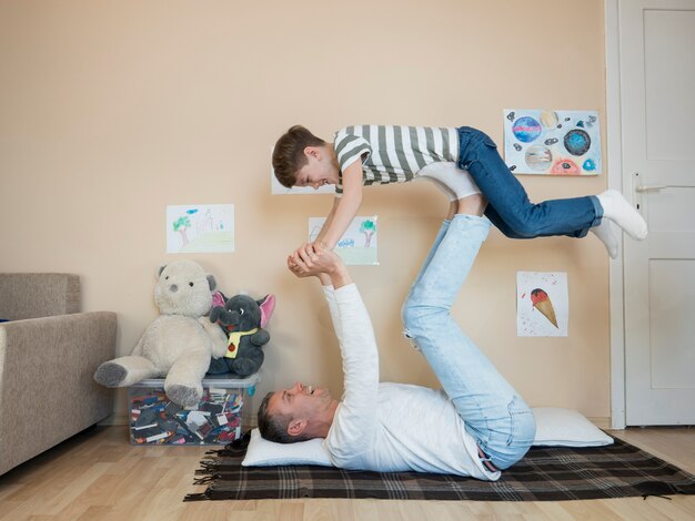 Padre sosteniendo a su hijo en el aire