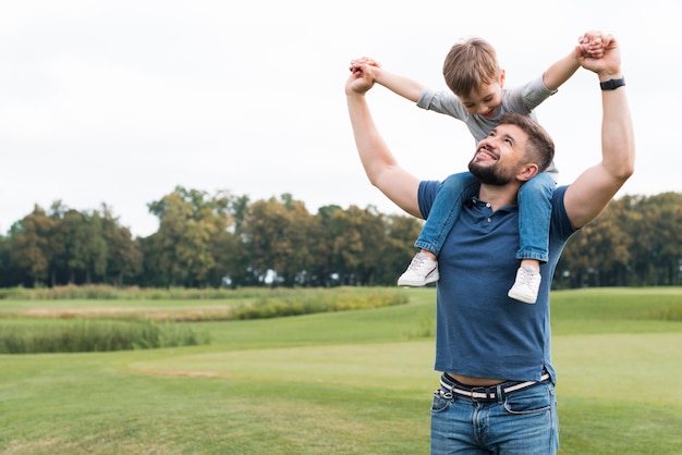 Padre sosteniendo a su hijo sobre sus hombros