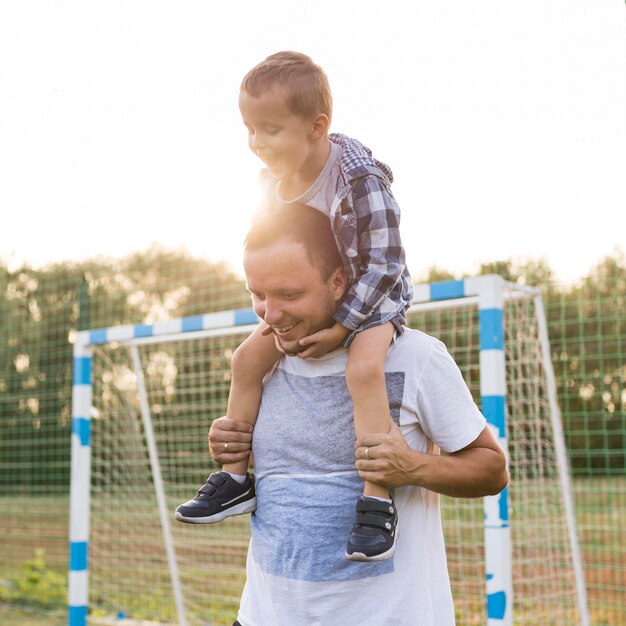 Padre sosteniendo a su hijo sobre sus hombros