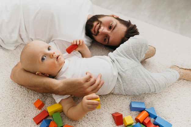 Padre y su bebé en el suelo en casa