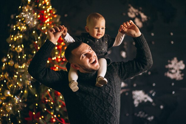 Padre con su hija por el árbol de navidad.