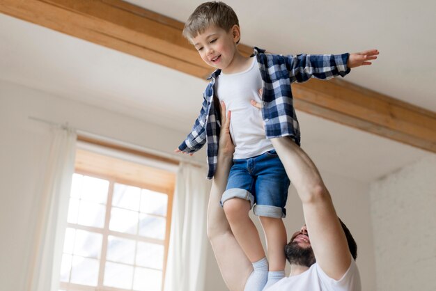 Padre con su hijo en el aire en el interior