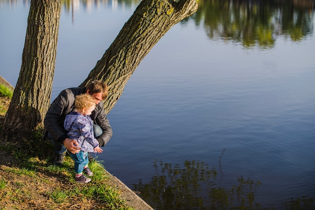 Padre con su hijo pequeño junto al lago