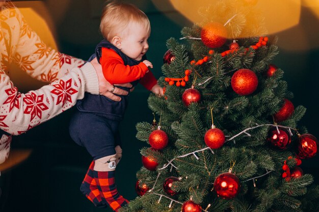 Padre con su pequeña hija por árbol de Navidad