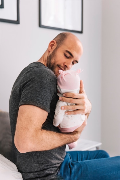 Padre sujetando bebé en dormitorio