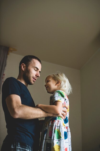 Padre sujetando por la cintura a su hija