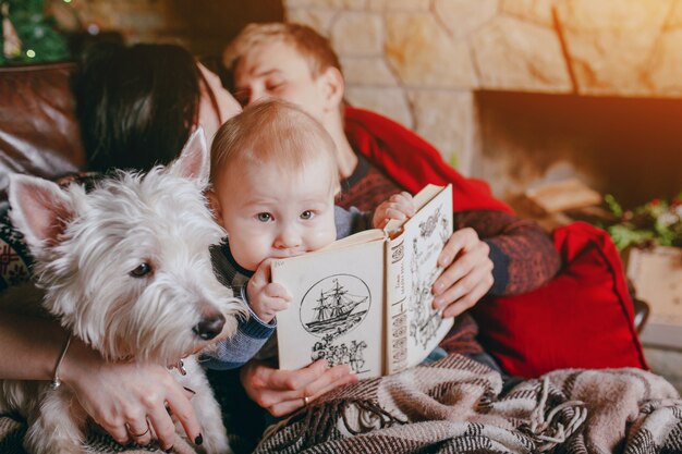 Padre sujetando un libro donde esta apoyado el bebé