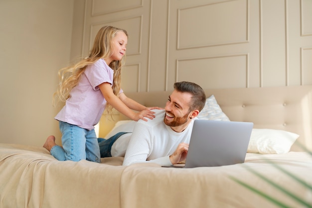 Foto gratuita padre de tiro completo trabajando de forma remota