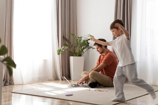 Padre de tiro completo trabajando en el piso