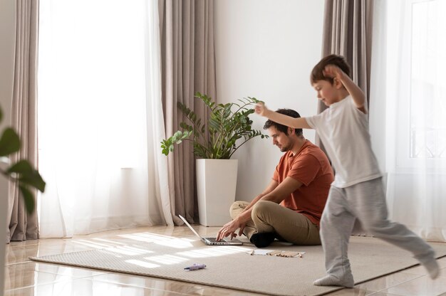 Padre de tiro completo trabajando en el piso