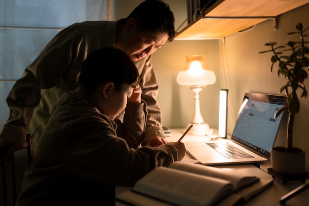 Foto gratuita padre de tiro medio ayudando a un niño con la tarea