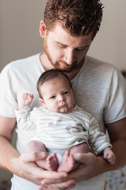 Foto gratuita padre de tiro medio cuidando al bebé