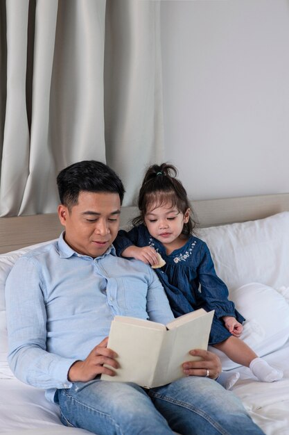 Padre de tiro medio leyendo a niña