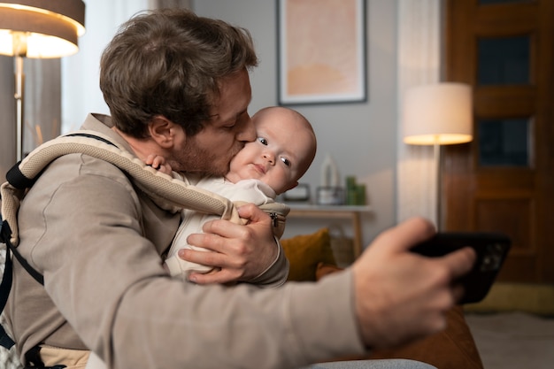 Padre de tiro medio tomando selfie con bebé